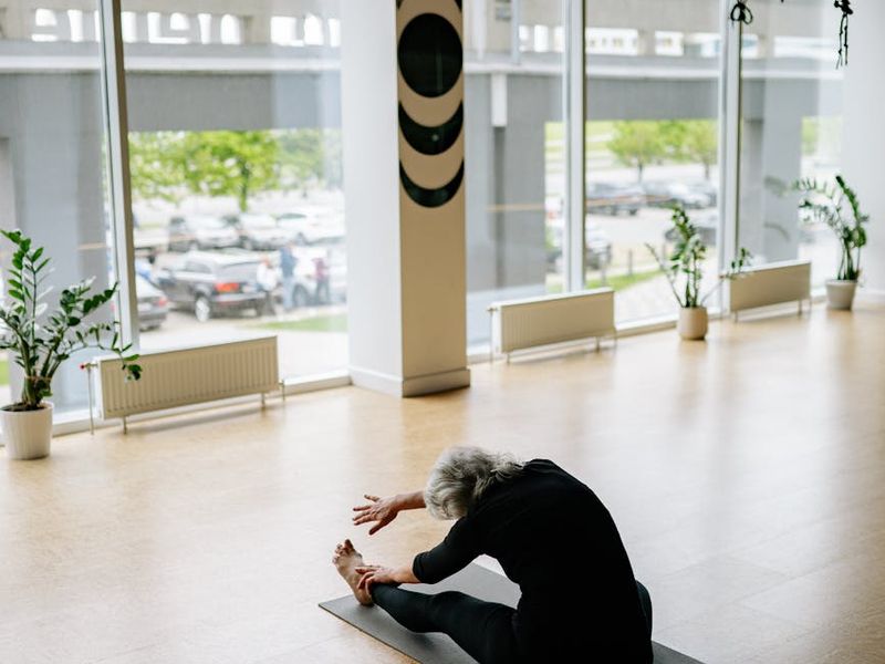 Woman performing a focused yoga sequence in a bright, spacious room.